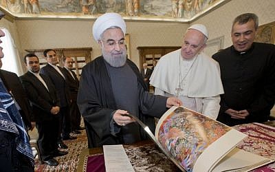 Iranian President Hassan Rouhani leafs through a book he gave to Pope Francis as a gift, during their private audience at the Vatican,Tuesday, Jan. 26, 2016. (AP Photo/Andrew Medichini, Pool)