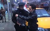 Egyptian actor and prankster Shady Hussein hands a policeman an inflated condom on January 25, 2016. (YouTube)