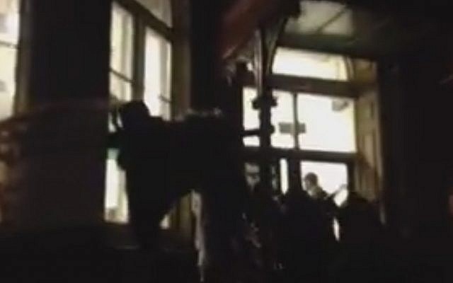 Pro-Palestinian activists bang on the windows of an Israel Society event featuring former Shin Bet chief Ami Ayalon at King's College, London on January 19, 2016 (screen capture: Facebook)