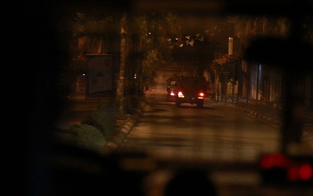 An IDF jeep travels down a road in Qalqilya on January 14, 2016. As the army vehicles left the city, some residents threw stones at the jeeps, not causing any damage. The three suspects the Tiger Battalion arrested were handed over to law enforcement later that morning. (Judah Ari Gross/Times of Israel)