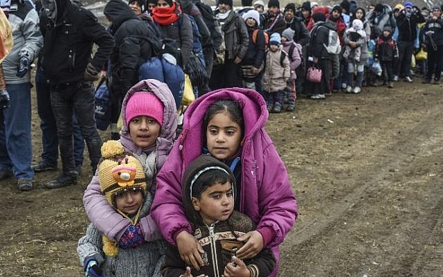 Children pose as they wait with other migrants and refugees in line for a security check after crossing the Macedonian border into Serbia, near the village of Miratovac, on January 26, 2016. (AFP / ARMEND NIMANI) Children pose as they wait with other migrants and refugees in line for a security check after crossing the Macedonian border into Serbia, near the village of Miratovac, on January 26, 2016. (AFP / ARMEND NIMANI)