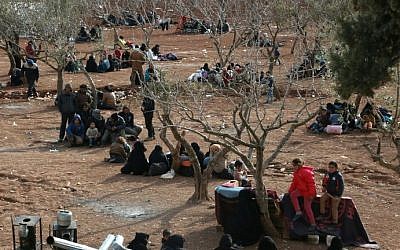 Syrians fleeing the northern embattled city of Aleppo wait in a field in the town of Iqda, next to the city of Azaz in northern Syria, on February 5, 2016. (AFP / STRINGER)