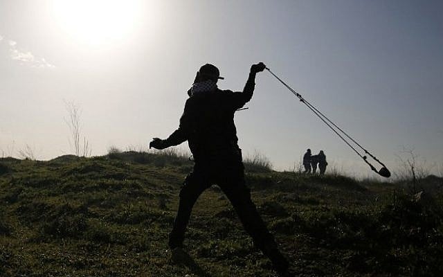 A Palestinian protester uses a slingshot to hurl stones towards Israeli security forces during clashes outside the compound of the Israeli-run Ofer Prison near Ramallah on February 5, 2016 (AFP / ABBAS MOMANI)