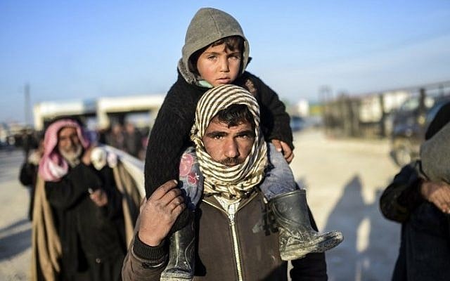 A man carries a child on his shoulders as Syrians fleeing the northern embattled city of Aleppo wait on February 5, 2016 in northern Syria, near the Turkish border. (AFP / BULENT KILIC) A man carries a child on his shoulders as Syrians fleeing the northern embattled city of Aleppo wait on February 5, 2016 in northern Syria, near the Turkish border. (AFP / BULENT KILIC)