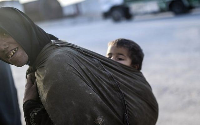 A woman carries a baby on her back as Syrians fleeing the northern embattled city of Aleppo wait on February 5, 2016 in Bab-Al Salama, next to the city of Azaz, northern Syria, near Turkish crossing gate. (AFP / BULENT KILIC) A woman carries a baby on her back as Syrians fleeing the northern embattled city of Aleppo wait on February 5, 2016 in Bab-Al Salama, next to the city of Azaz, northern Syria, near Turkish crossing gate. (AFP / BULENT KILIC)