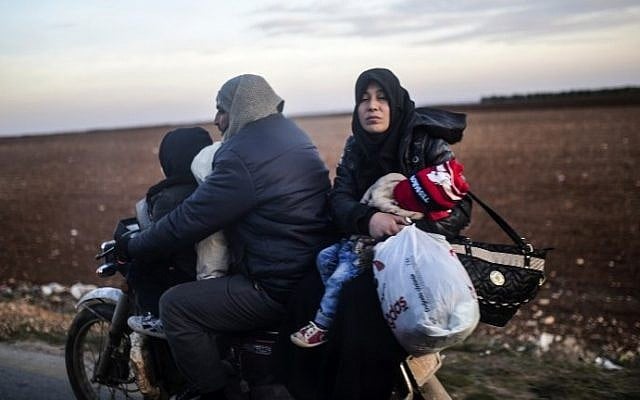 A Syrian family fleeing the northern embattled city of Aleppo wait on February 5, 2016 in Bab-Al Salama, next to the city of Azaz, northern Syria, near Turkish crossing gate. (AFP / BULENT KILIC)