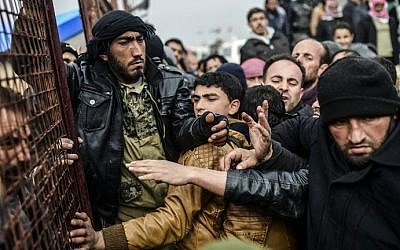 Refugees push each other as they wait for tents as Syrians fleeing the northern embattled city of Aleppo wait on February 6, 2016 in Bab al-Salama, near the city of Azaz, northern Syria, near the Turkish border crossing. (Bulent Kilic/AFP)