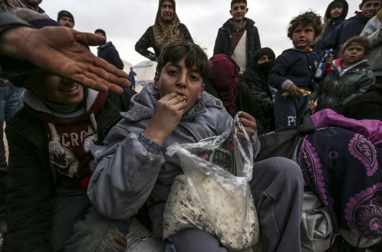 Syrian refugees fleeing the northern embattled city of Aleppo wait on February 6, 2016 in Bab al-Salama, near the city of Azaz, northern Syria, near the Turkish border crossing. Turkey on Saturday said it was expecting a huge wave of Syrians fleeing a government onslaught on rebel-held territory, with a regional governor saying at least 70,000 people may be heading for the border. The United Nations said some 20,000 people had gathered at Syria's Bab al-Salam crossing with Turkey. An AFP reporter said the crossing was closed but the Syrian side of it was being supplied by aid trucks coming from Turkey. / AFP / BULENT KILIC Syrian refugees fleeing the northern embattled city of Aleppo wait in Bab al-Salama, in northern Syria, near the Turkish border (AFP / BULENT KILIC)