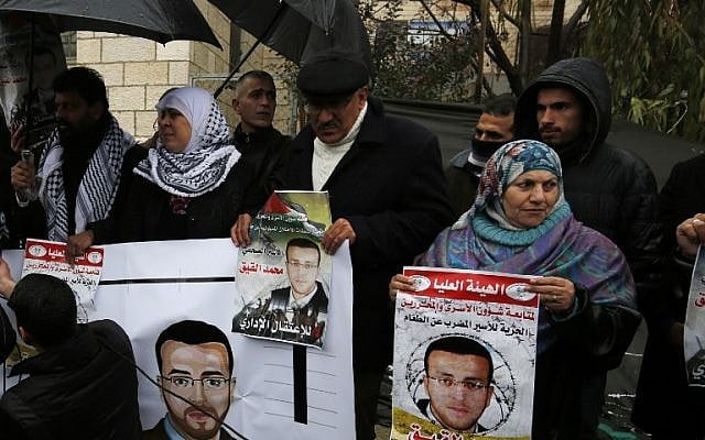 Supporters of hunger-striking Palestinian prisoner Mohammed al-Qiq hold portraits as they demonstrate in solidarity with him outside the offices of the International Committee of the Red Cross near the West Bank city of Ramallah, February 7, 2016. (AFP/Abbas Momani) Supporters of hunger-striking Palestinian prisoner Mohammed al-Qiq hold portraits as they demonstrate in solidarity with him outside the offices of the International Committee of the Red Cross near the West Bank city of Ramallah, February 7, 2016. (AFP/Abbas Momani)