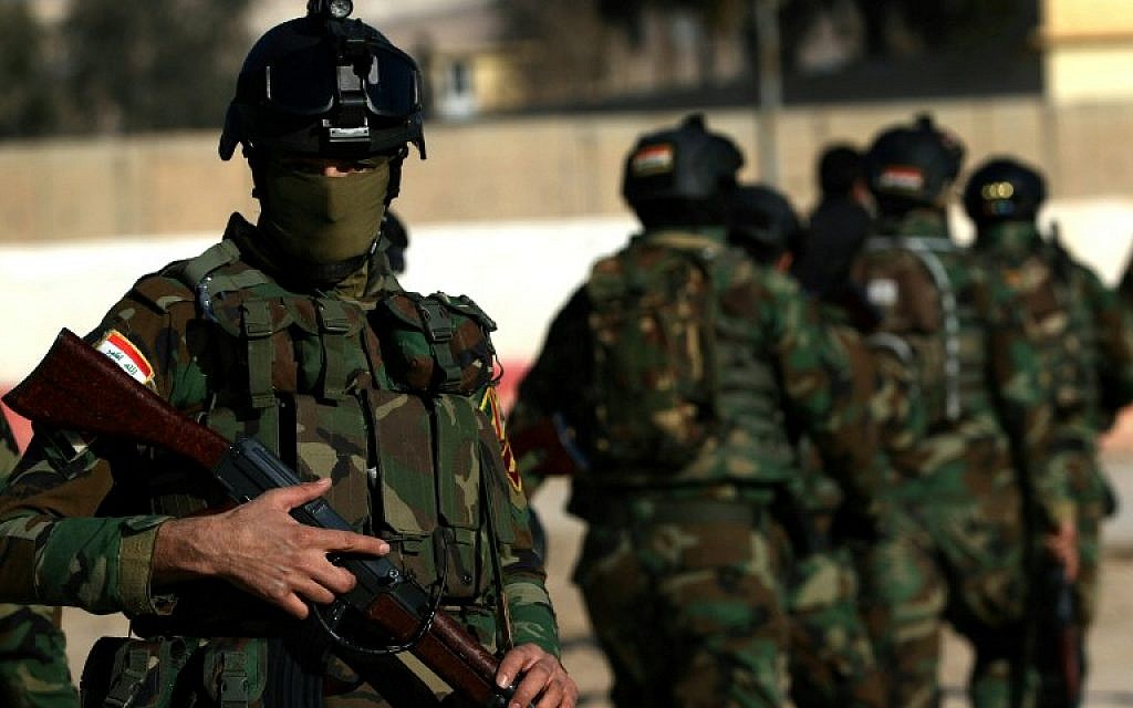 Iraqi soldiers stand guard at the entrance of the Nineveh base for liberation operations in Makhmur, about 280 kilometres (175 miles) north of the capital Baghdad, on February 11, 2016.  (SAFIN HAMED/AFP)