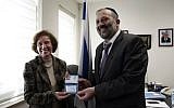 German Nazi-hunter Beate Klarsfeld (L) receives her new Israeli passport and ID from Interior Minister Aryeh Deri during a ceremony at the Interior Ministry in Jerusalem, February 15, 2016. (Thomas Coex/AFP)