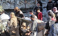 People carry a stretcher amid debris after a hospital supported by Doctors Without Borders was hit by suspected Russian air strikes near Maaret al-Numan, in Syria's northern province of Idlib, on February 15, 2016. (AFP / Omar haj kadour)