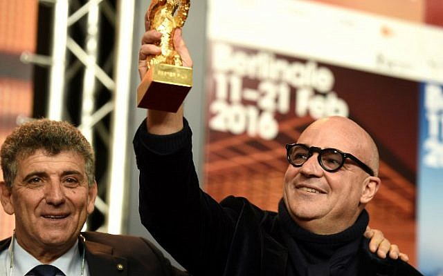 Pietro Bartolo (L), director of a hospital on the Italian island of Lampedusa, poses with Italian director Gianfranco Rosi holding his Golden Bear for Best Film for the film "Fuocoammare" (Fire at Sea) at a press conference after the awards ceremony of the 66th Berlinale, Europe's first major film festival of the year, on February 20, 2016 in Berlin. (Odd Andersen/AFP)