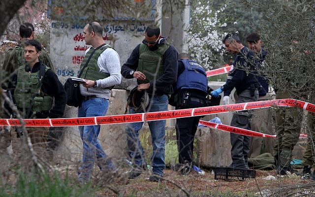 Israeli security forces gather around the body of a Palestinian man who tried to stab an Israeli soldier before being shot dead, at the Bitot Junction south of Nablus on February 21, 2016. (AFP / JAAFAR ASHTIYEH)