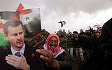 Syrian volunteers and their relatives wave the national flag and portraits of President Bashar Assad as they celebrate at the end of a paramilitary training conducted by the Syrian army on February 22, 2016. (AFP / LOUAI BESHARA)