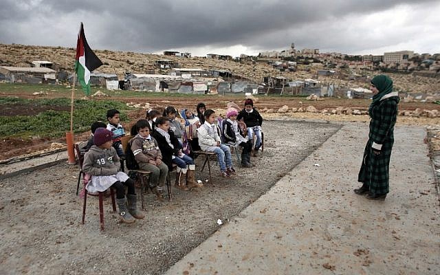 A Palestinian teacher leads a class of Palestinian Bedouin children from the Abu Anwar community near the Jewish settlement of Maale Adumim (background), in the West Bank city of al-Azariya, east of Jerusalem, on February 23, 2016. (AFP / AHMAD GHARABLI) A Palestinian teacher leads a class of Palestinian Bedouin children from the Abu Anwar community near the Jewish settlement of Maale Adumim (background), in the West Bank city of al-Azariya, east of Jerusalem, on February 23, 2016. (AFP / AHMAD GHARABLI)