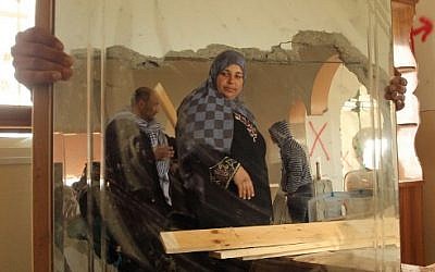 Relatives inspect the damaged interior of the home of Mohammed al-Harub, a Palestinian man accused of opening fire at a junction near Israeli settlements in the West Bank then ramming his car into a group of pedestrians, after it was demolished by Israeli bulldozers near the West Bank village of Dura on February 23, 2016. (AFP / HAZEM BADER)