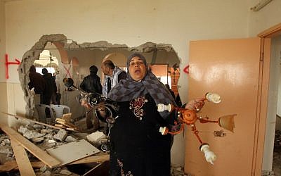Relatives inspect the damaged interior of the home of Mohammed al-Harub, a Palestinian man accused of opening fire at a junction near Israeli settlements in the West Bank then ramming his car into a group of pedestrians, after it was demolished by Israeli bulldozers near the West Bank village of Dura on February 23, 2016. (AFP / HAZEM BADER)