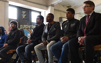 The Bavarian Minister for Justice Winfried Bausback (R) and refugee's follow the rights education lessons for refugees and asylum seekers in a hall of the "Bayernkaserne" in Munich, southern Germany on February 24, 2016. (Christof Stache/AFP)