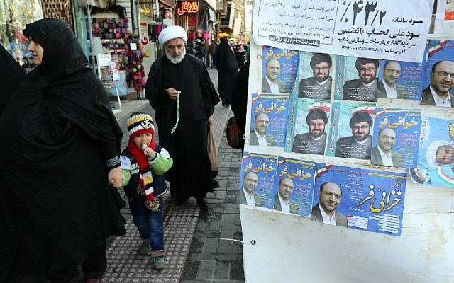 An Iranian cleric walks past electoral posters for upcoming parliamentary elections, near the Hazrat Fatimah Ma'sumeh mausoleum in Qom, on February 24, 2016. (AFP PHOTO / ATTA KENARE) An Iranian cleric walks past electoral posters for upcoming parliamentary elections, near the Hazrat Fatimah Ma'sumeh mausoleum in Qom, on February 24, 2016. (AFP PHOTO / ATTA KENARE)