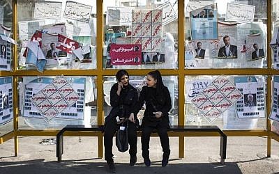 Iranian women sit at a bus station decorated with electoral posters of the upcoming parliamentary elections in downtown Tehran on February 25, 2016. (AFP / BEHROUZ MEHRI) Iranian women sit at a bus station decorated with electoral posters of the upcoming parliamentary elections in downtown Tehran on February 25, 2016. (AFP / BEHROUZ MEHRI)