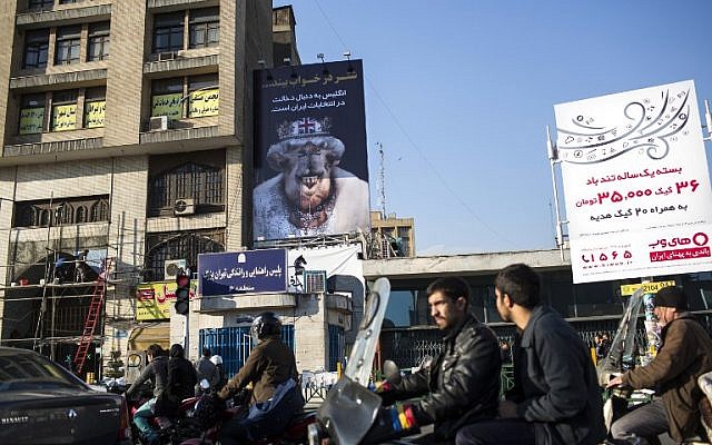 Iranians commute past a banner with a cartoon depicting Britain's Queen Elizabeth II with a camel head and a slogan that reads, 'England wants to interfere in Iran's elections' in downtown Teheran on February 25, 2016. (AFP/Behrouz Mehri) Iranians commute past a banner with a cartoon depicting Britain's Queen Elizabeth II with a camel head and a slogan that reads, 'England wants to interfere in Iran's elections' in downtown Teheran on February 25, 2016. (AFP/Behrouz Mehri)