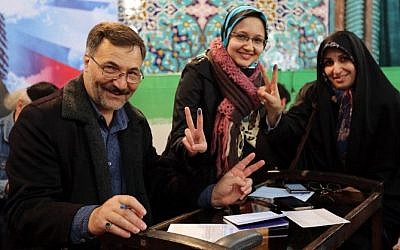 Iranians display their ink-stained finger after casting their ballot for both parliamentary elections and the Assembly of Experts at a polling station in Tehran on February 26, 2016. (AFP / ATTA KENARE)