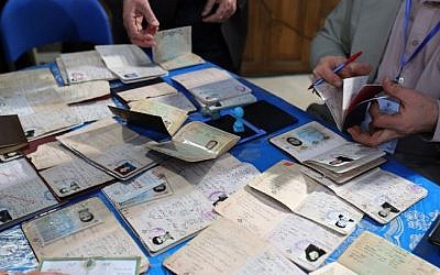 Iranian men register before casting their vote at a polling station in Tehran on February 26, 2016 (AFP / ATTA KENARE)