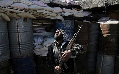 A Syrian rebel fighter from the Islamist Failaq al-Rahman brigade mans a position on the frontline against regime forces in the town of Arbin in the eastern Ghouta region on the outskirts of the capital Damascus on February 26, 2016. (AMER ALMOHIBANY via AFP)