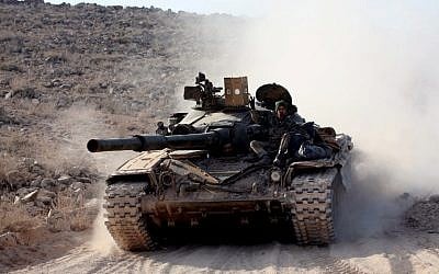 Syrian government forces drive a tank on a road during a military operation against the Islamic State (IS) group in the villages of Zarour and Khanaser, in the Aleppo governorate, on February 26, 2016. (AFP/GEORGES OURFALIAN)