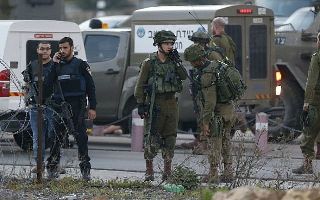 Israeli security forces monitor the area where a Palestinian man tried to stab Israeli soldiers before being shot dead at a checkpoint near Ramallah in the West Bank, February 26, 2016. (AFP/Abbas Momani)