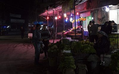 Syrian men shop at a vegetables market in the northern Syrian city of Aleppo on February 26, 2016, just hours before a midnight deadline for a landmark ceasefire in the country's five-year civil war. (AFP/KARAM AL-MASRI)