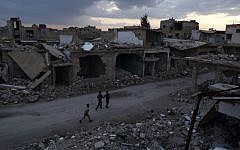 Syrian children walk past heavily damaged buildings in the rebel-held town of Douma, on the eastern edge of the capital Damascus, on the first day of the cease-fire agreement, February 27, 2016. (AFP/Sameer al-Doumy)