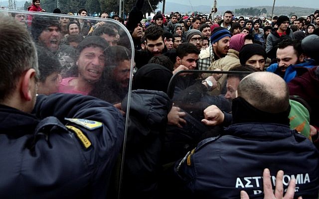 Refugees try to break into the Greek police blockade towards the border fence of Macedonia during a protest demanding the opening of the borders near the village of Idomeni on February 29, 2016. (AFP / LOUISA GOULIAMAKI)
