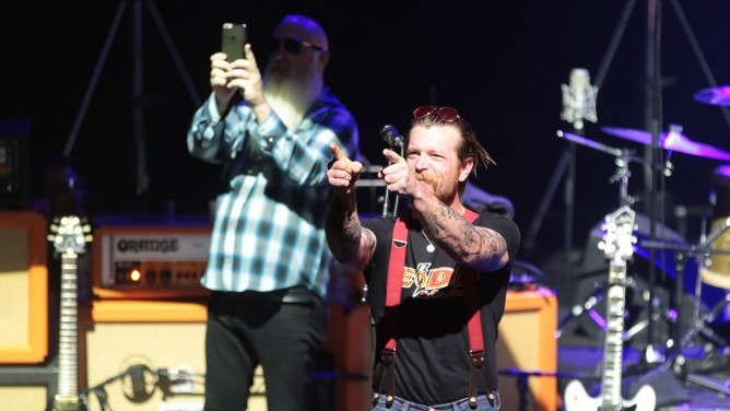 Jesse Hughes (C), the singer of US rock group Eagles of Death Metal, gestures during their concert at the Olympia concert hall in Paris, on February 16, 2016 (AFP PHOTO / JOEL SAGET)