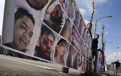 Protesters hold a banner depicting victims of Bahrain's anti-regime protests as they demonstrate against the candidacy of Sheikh Salman bin Ebrahim al-Khalifa on the sidelines of the extraordinary FIFA Congress during which a new president will be elected at the headquarters of the world's governing body of football in Zurich on February 26, 2016. (AFP PHOTO/OLIVIER MORIN)
