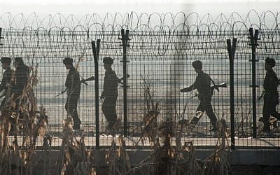 North Korean soldiers patrol next to the border fence near the town of Sinuiju across from the Chinese border town of Dandong on February 10, 2016 (AFP PHOTO / JOHANNES EISELE)