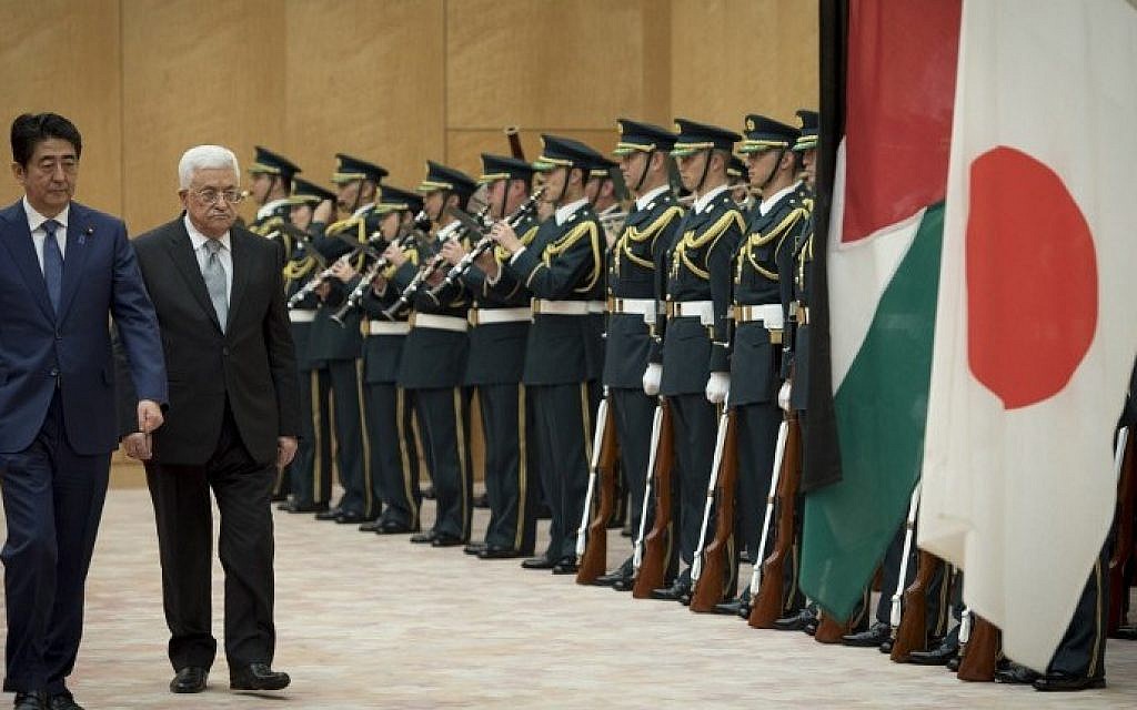 Palestinian Authority President Mahmoud Abbas (2nd L) walks with Japan's Prime Minister Shinzo Abe (L) as they review an honor guard prior to their meeting at Abe's official residence in Tokyo on February 15, 2016. (Nicolas Datiche/AFP)