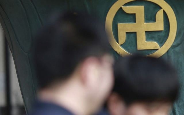 Visitors walk by a religious ornament with the "manji" sign, the mirror image of a swastika, which comes from the ancient Sanskrit and has been widely used for centuries to denote Buddhist temples on maps and elsewhere, at a temple in Tokyo, February 3, 2016 (AP Photo/Eugene Hoshiko) Visitors walk by a religious ornament with the "manji" sign, the mirror image of a swastika, which comes from the ancient Sanskrit and has been widely used for centuries to denote Buddhist temples on maps and elsewhere, at a temple in Tokyo, February 3, 2016 (AP Photo/Eugene Hoshiko)