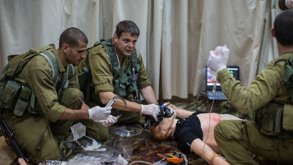 Dr. Amit Alfassi, center, treats a 'patient,' a smart doll that mimics the human respiratory and circulatory systems, in the Medical Simulation Center at Tel Hashomer Hospital in Ramat Gan on February 11, 2016. (Adi Brown/IDF Spokesperson's Unit) Dr. Amit Alfassi, center, treats a 'patient,' a smart doll that mimics the human respiratory and circulatory systems, in the Medical Simulation Center at Tel Hashomer Hospital in Ramat Gan on February 11, 2016. (Adi Brown/IDF Spokesperson's Unit)