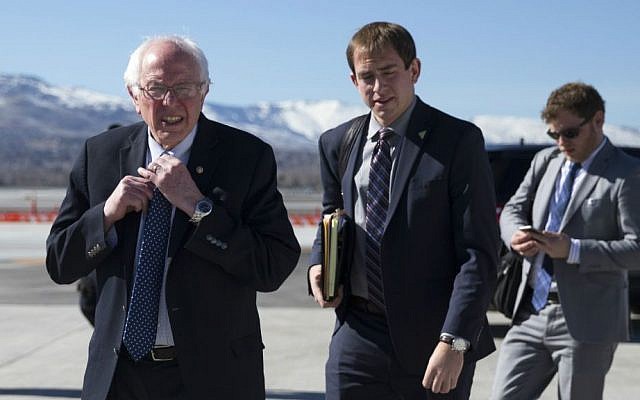 Democratic presidential candidate Sen. Bernie Sanders, I-Vermont, adjusts his tie as he walks to address the media before departing the airport for campaign events in Colorado, Saturday, Feb. 13, 2016, in Reno, Nevada. (AP Photo/Evan Vucci)