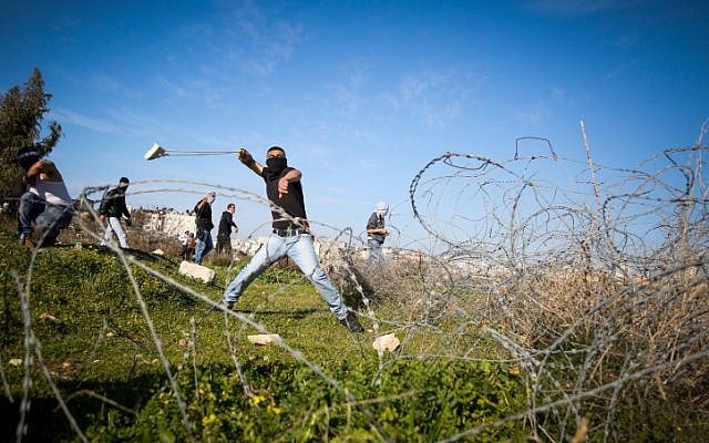 Illustration. Palestinian uses a sling to hurl stones towards Israeli troops (unseen) during clashes near the West Bank city of Ramallah on February 12, 2016. (Flash90) Illustration. Palestinian uses a sling to hurl stones towards Israeli troops (unseen) during clashes near the West Bank city of Ramallah on February 12, 2016. (Flash90)