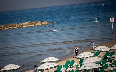 Israelis enjoy the beach in Tel Aviv on a warm winter day, February 17, 2016. (Miriam Alster/FLASH90)