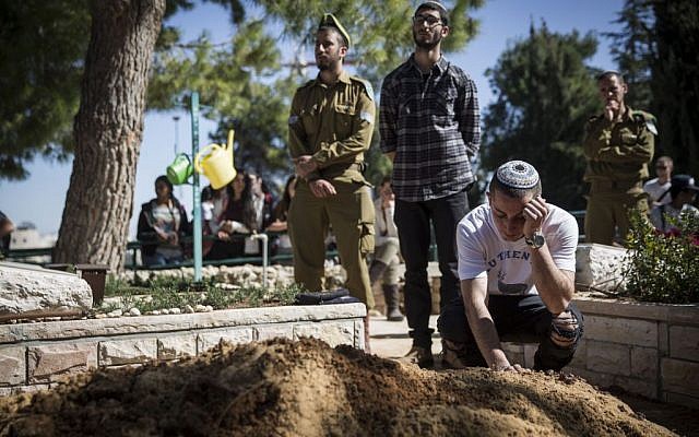 Friends seen mourning at the funeral of Tuvia Yanai Weissman,at the Mount Herzl military cemetery in Jerusalem, on February 18, 2016. (Hadas Parush/Flash90)