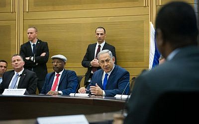 Prime Minister Benjamin Netanyahu attends a conference on Israeli-African relations, organized by Likud parliament member Avraham Negusie (in cap), at the Knesset on February 29, 2016. (Miriam Alster/FLASH90)