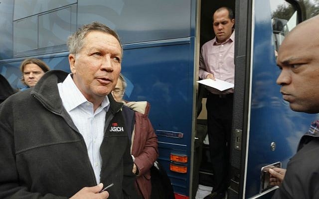 Republican presidential candidate Ohio Gov. John Kasich heads to the next stop after a town hall stop before the start of the nation's first presidential primary, Monday, Feb. 1, 2016, in Rochester, New Hampshire. (AP Photo/Jim Cole)