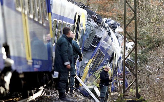 Police stand beside two trains that collided head-on near Bad Aibling, southern Germany, Tuesday, Feb. 9, 2016 (Uwe Lein/dpa via AP)
