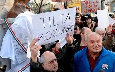 Demonstrators protest against the installation of a statue of Gyorgy Donath, a Hungarian wartime politician executed in 1947, prior to the unveiling ceremony to be held as part of commemorations for the victims of communism in Budapest, Hungary, Wednesday, Feb. 24, 2016. (Tamas Kovacs/MTI via AP)