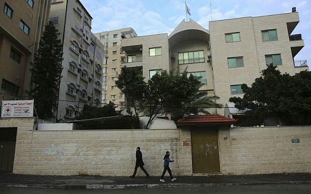 Palestinians walk past an office of the International Committee of the Red Cross that was temporarily closed after protesters repeatedly tried to storm it, in Gaza City, Sunday, Feb. 7, 2016. (AP Photo/Adel Hana)