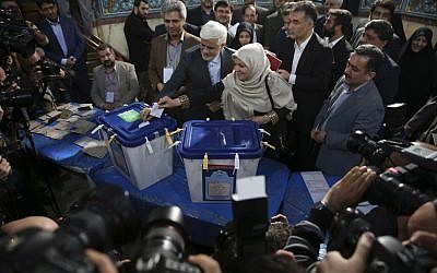 Head of the reformists' coalition list of the Iranian parliamentary elections in Tehran Mohammad Reza Aref, center, and his wife Hamideh Moravej Farshi cast their ballots at a polling station in northern Tehran, Iran, Friday, Feb. 26, 2016. (AP Photo/Vahid Salemi)